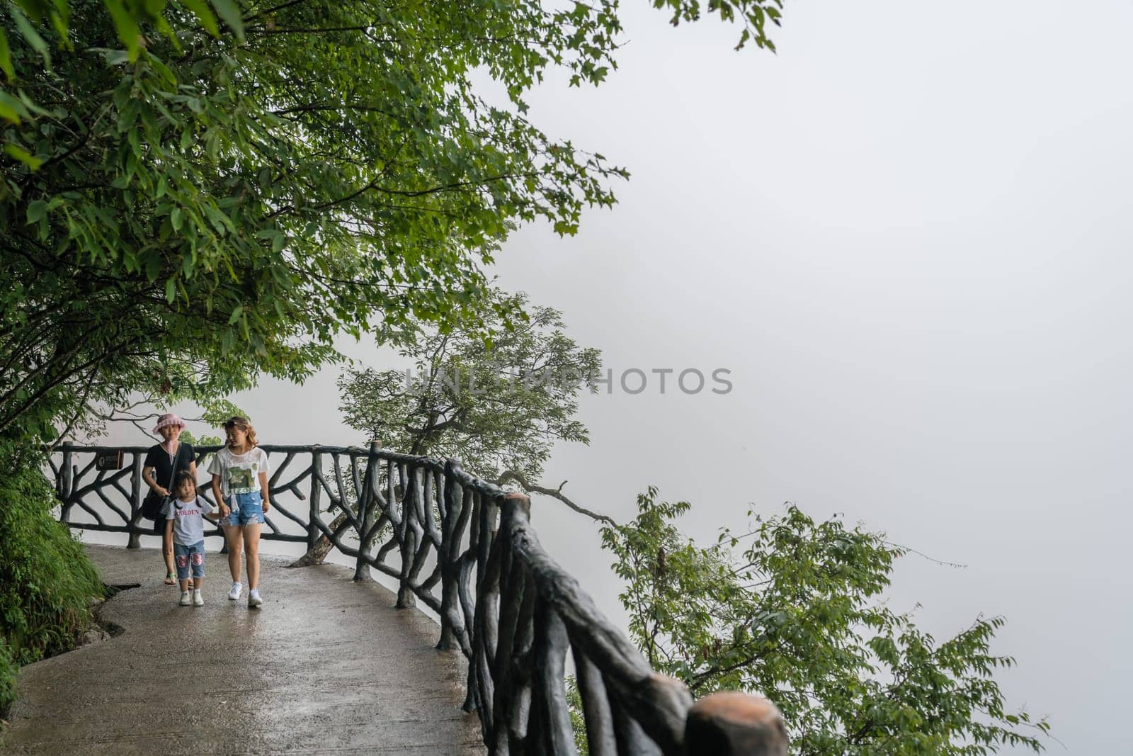 Zhangjiajie, China - August 2019 : Tourists walking on the popular narrow path on the top of the cliff which is called Sky Walk at Tianmen Mountain, Zhangjiajie forest National Park, Hunan Province