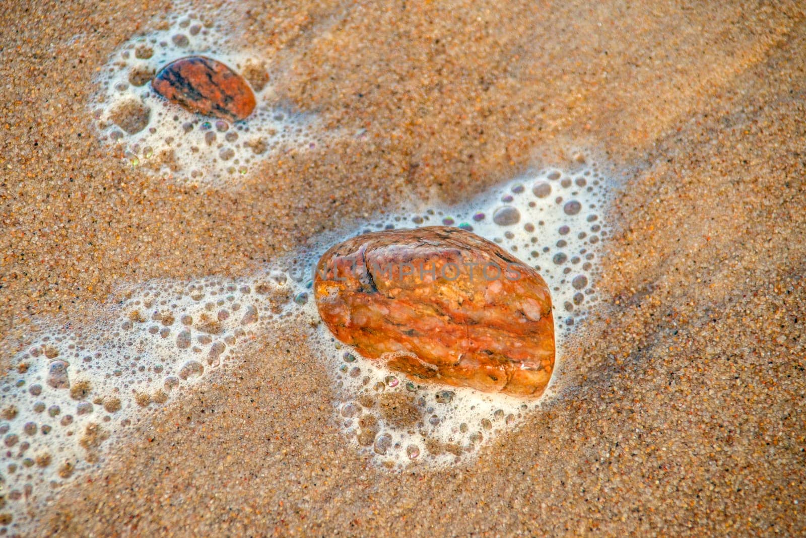 sandy beach with pebble and spray of the surf