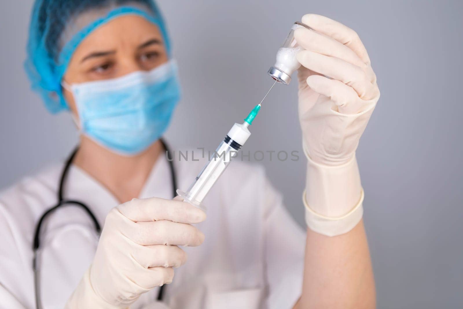 Doctor hands filling the syringe with vaccine. Medical treatment concept. Focus is on syringe.