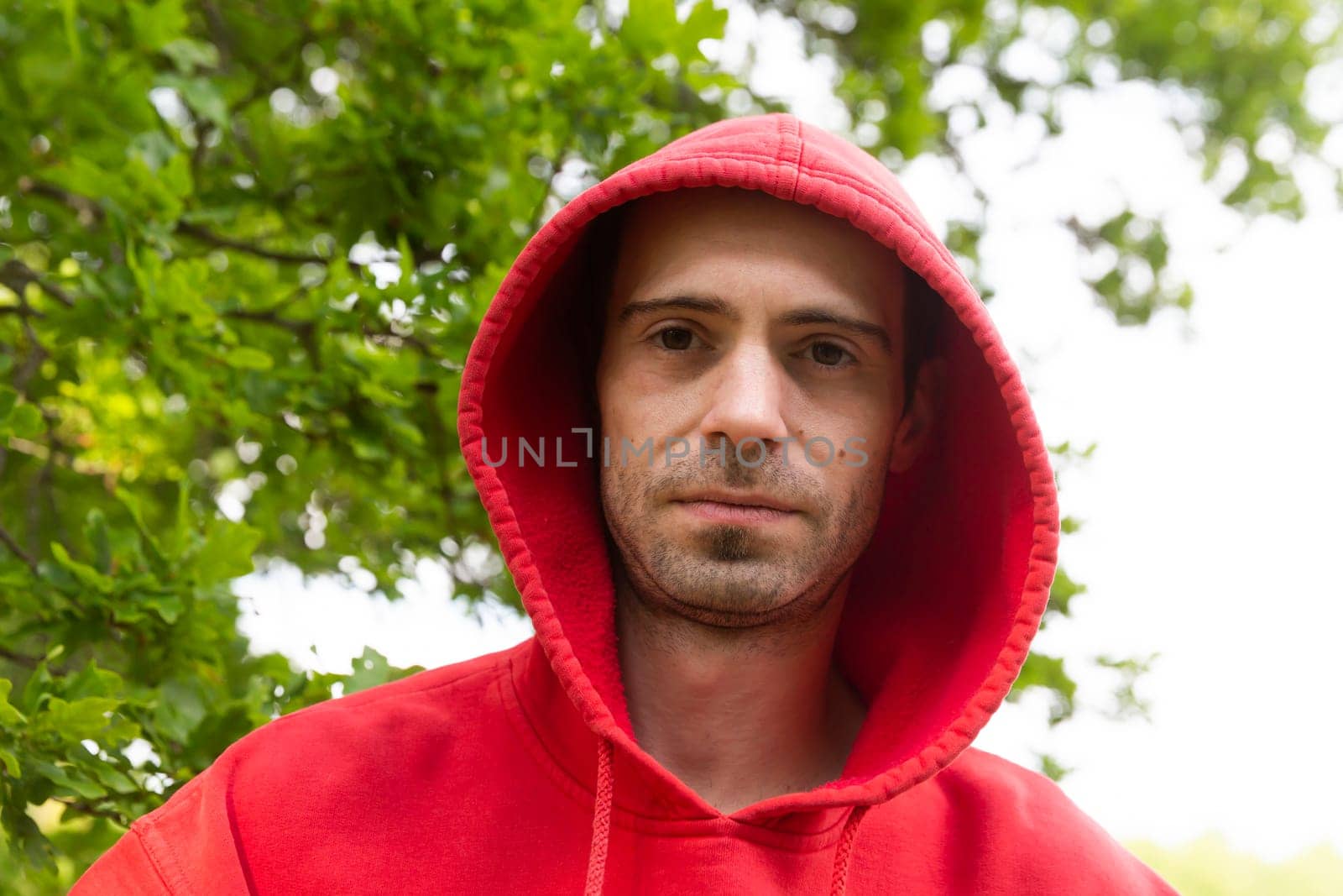 Portrait from young man with red hoodie looking real serious