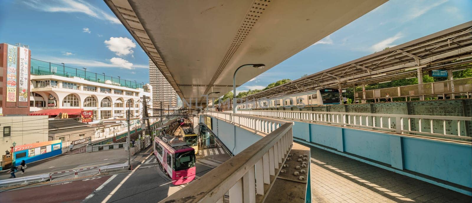 Oji station JR Keihin Tohoku Line in the Kita district, north of Tokyo. The pedestrian walkway spans the intersection of Meiji Avenue where the Ojiekimae station of the Toden Arakawa tram line is famous for its retro style.