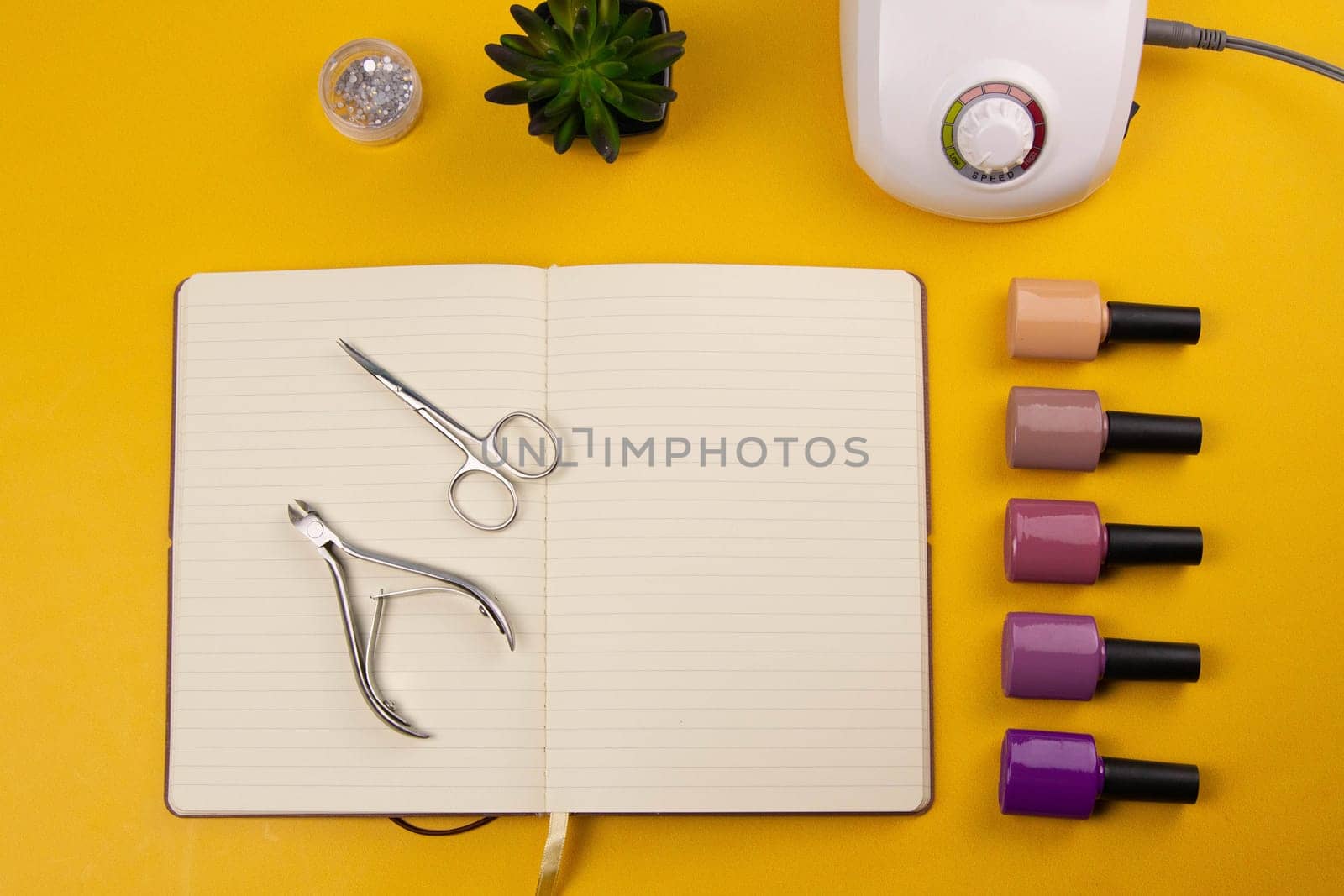A set of cosmetic tools for manicure and pedicure stand on a black background. scissors and tongs. Top views
