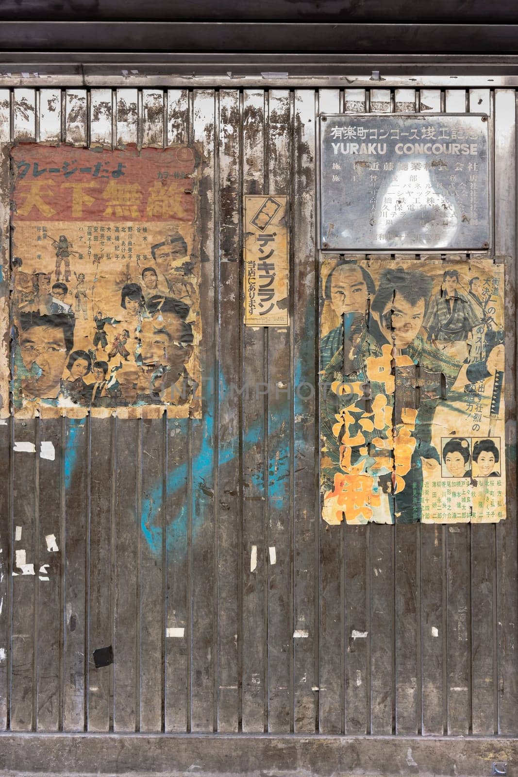 Old vintage retro japanese movie posters on underpass Yurakucho Concourse wall under the railway line of the station Yurakucho. Japanese noodle stalls and sake bars revive the nostalgic years of Showa air with old samurai posters and placards glued to the walls of the tunnel.