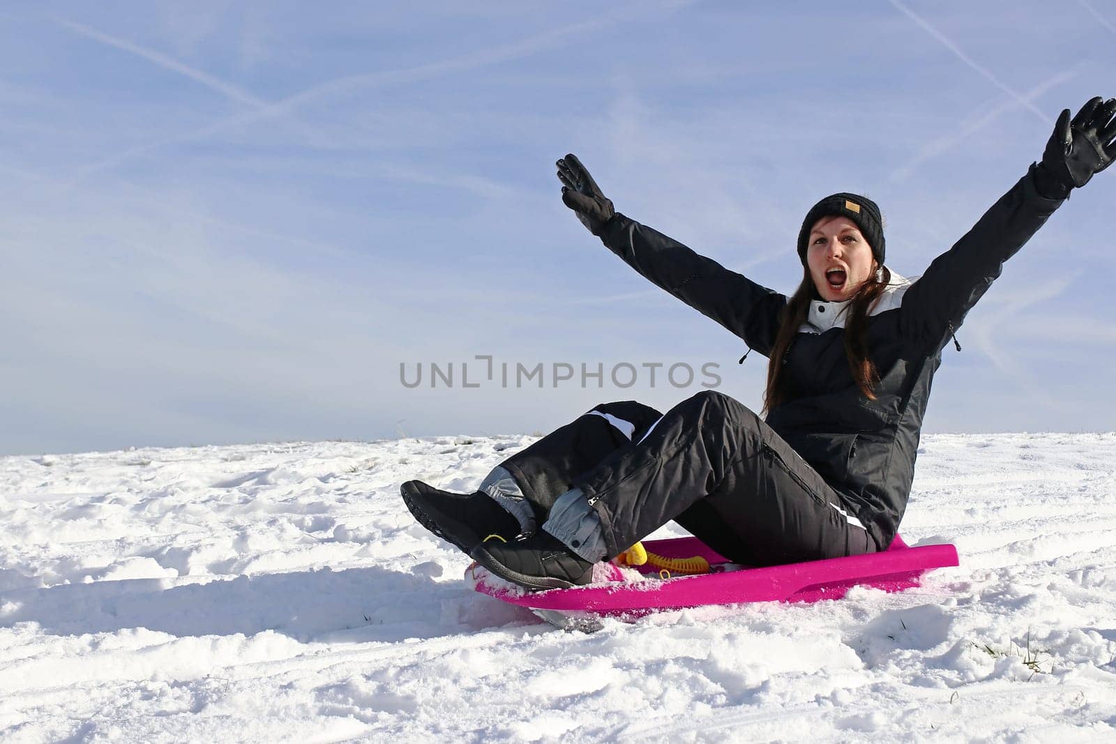 A young woman has fun sledging in winter