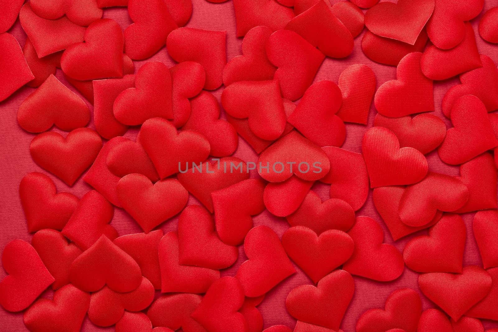 Valentine background from red silk hearts. Valentine's Day card. Top view with copy space. Design element for romantic greeting card, invitation. Women's Day. Hearts background. Wedding day.