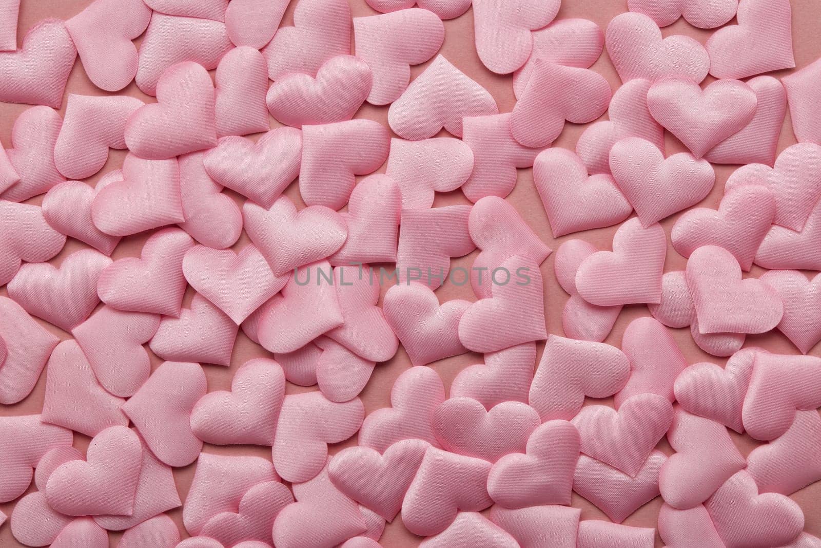 Valentine background from pink silk hearts. Valentine's Day card. Top view with copy space. Design element for romantic greeting card, invitation. Women's Day. Hearts background. Wedding day.