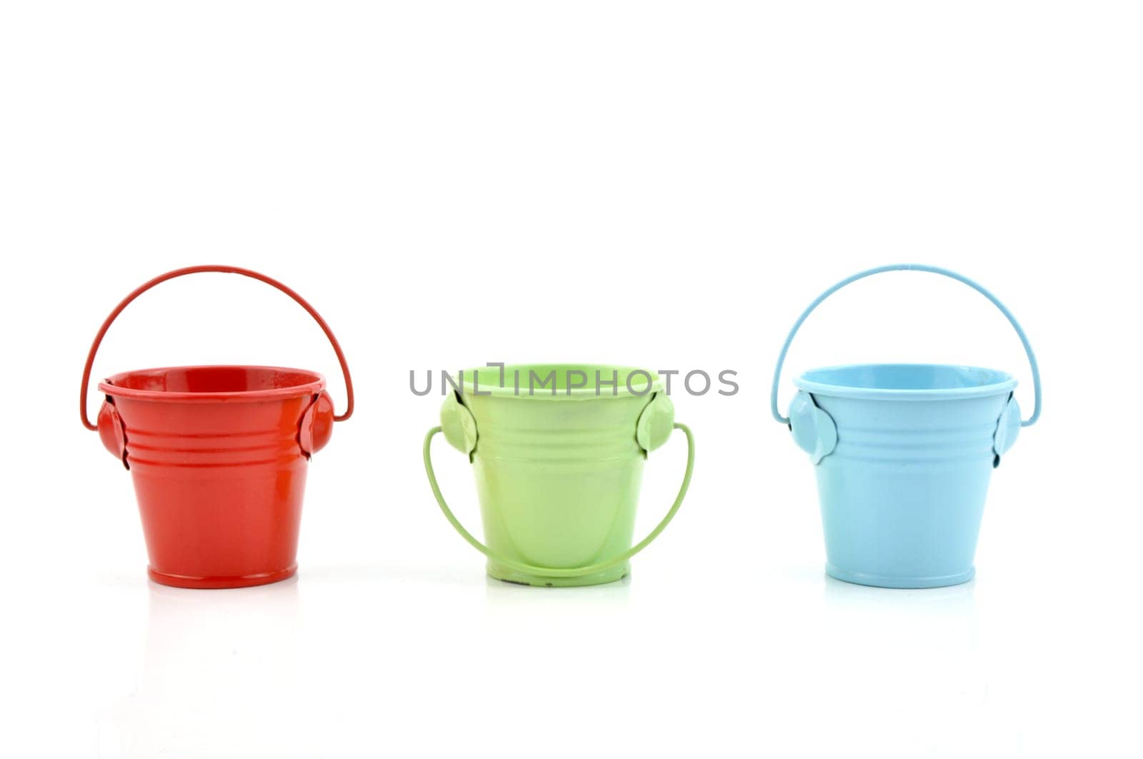 Three metal buckets of different colours with handle, isolated on white background