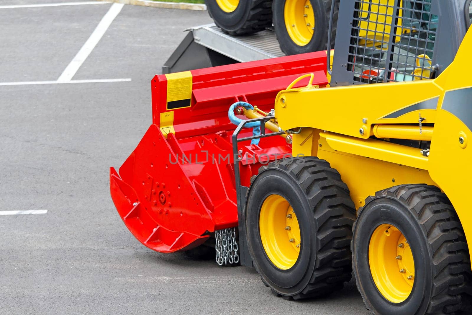 Skid steer construction machine with interchangeable attachment
