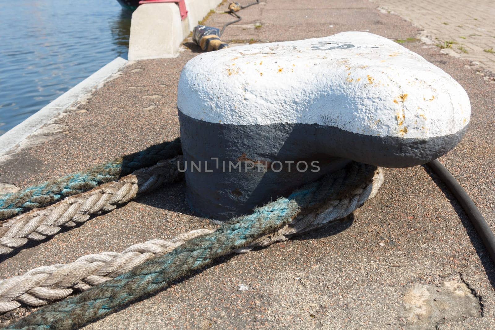 Ship mooring rope moored on the bollard.