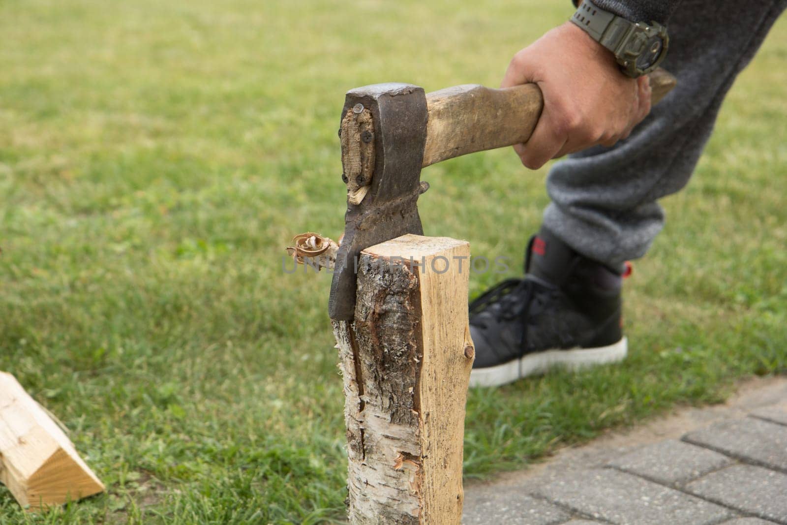 Preparation for a picnic. The man with the ax prepares the firewood for the fire