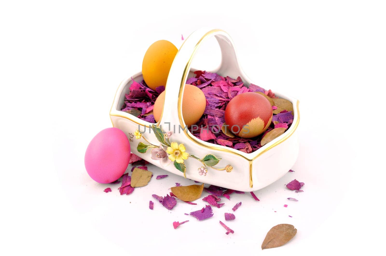 Handmade easter eggs in a basket with wooden decoration