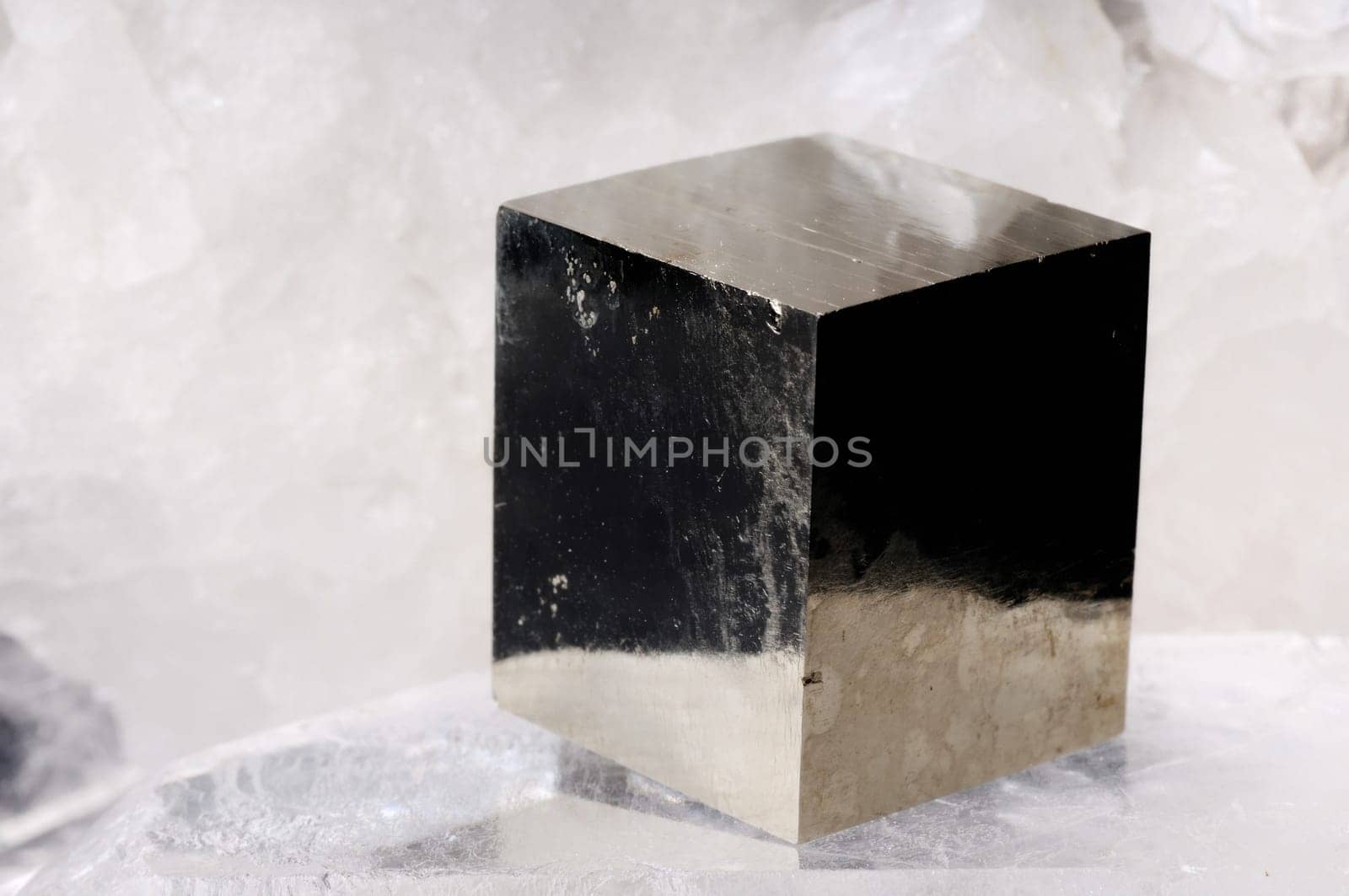 Pyrite cube crystal on quartz background