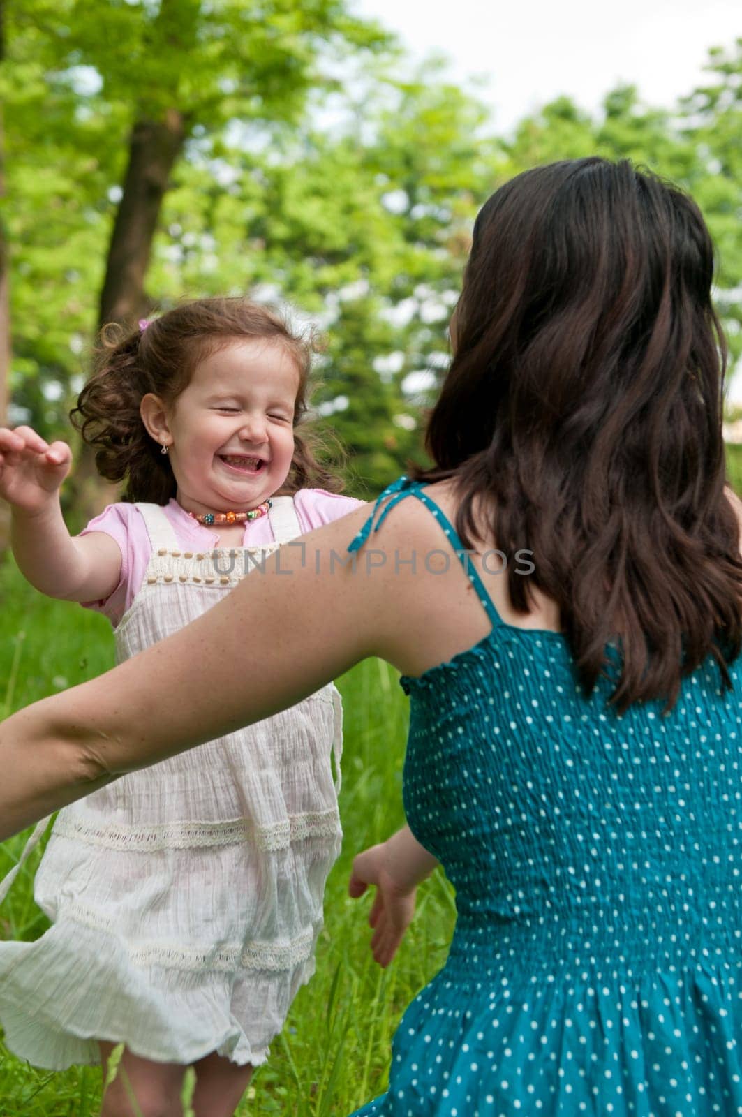 Small girl enjoying life with her mother outdoors