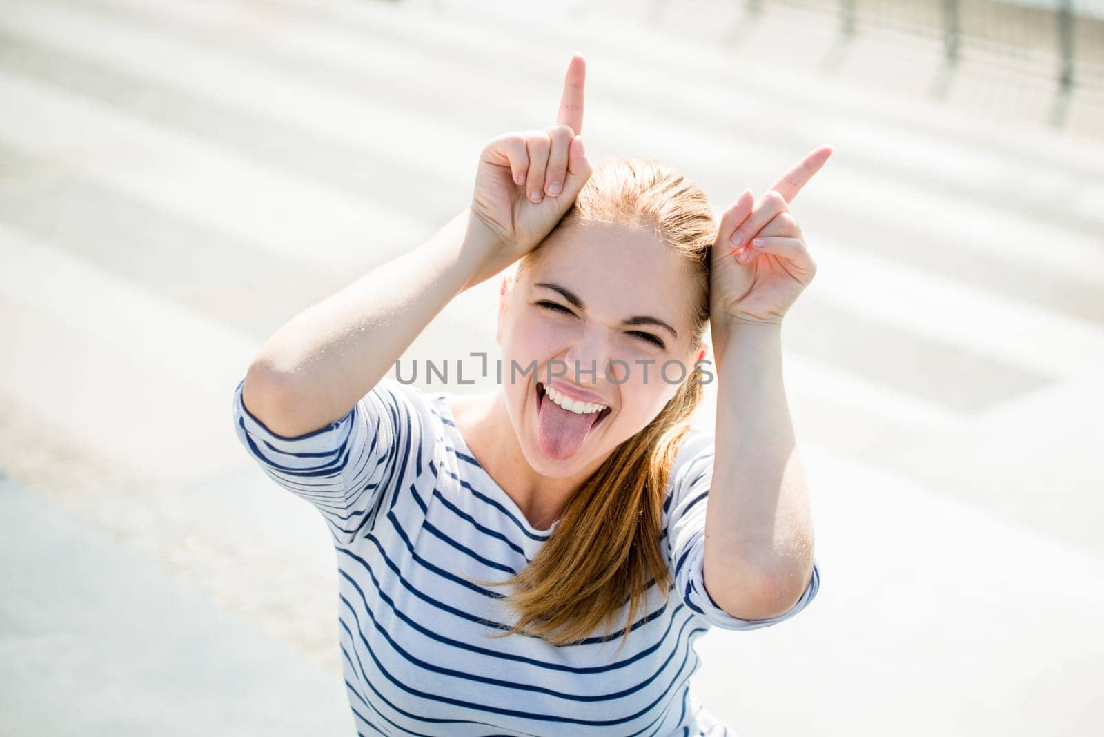 Teenager portrait - smiling girl has fun and pretends she is devil