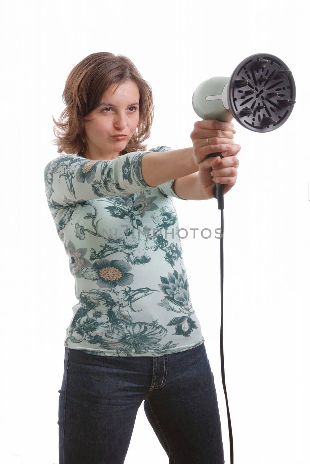 Young woman in casual dress shoots with hairdryer - isolated on white background