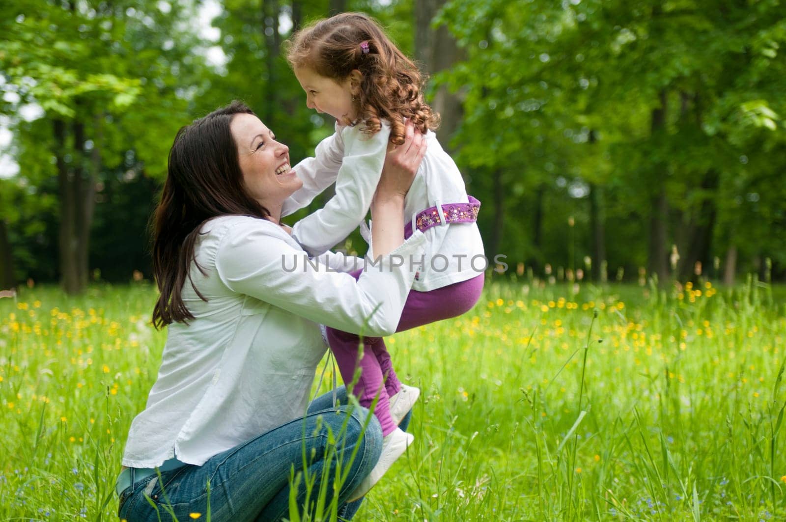 Small girl enjoying life with her mother outdoors