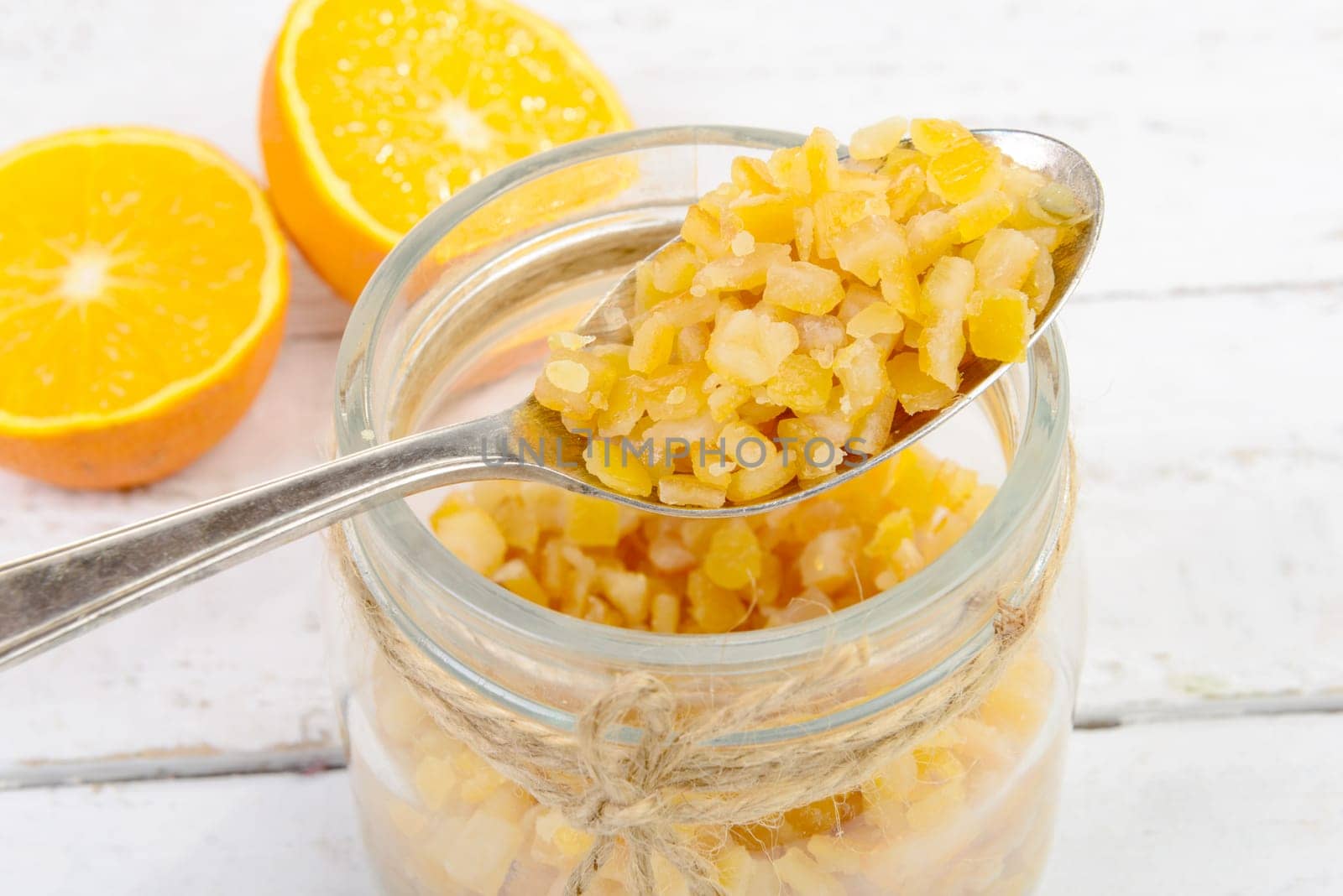 candied oranges cut into pieces on the white wooden table