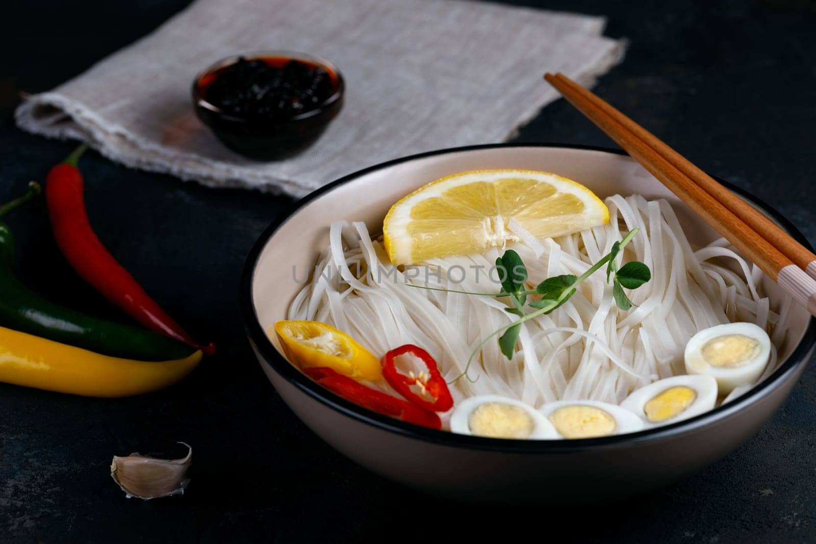Rice noodles, Asian cuisine, with quail eggs, chili pepper and pea sprout