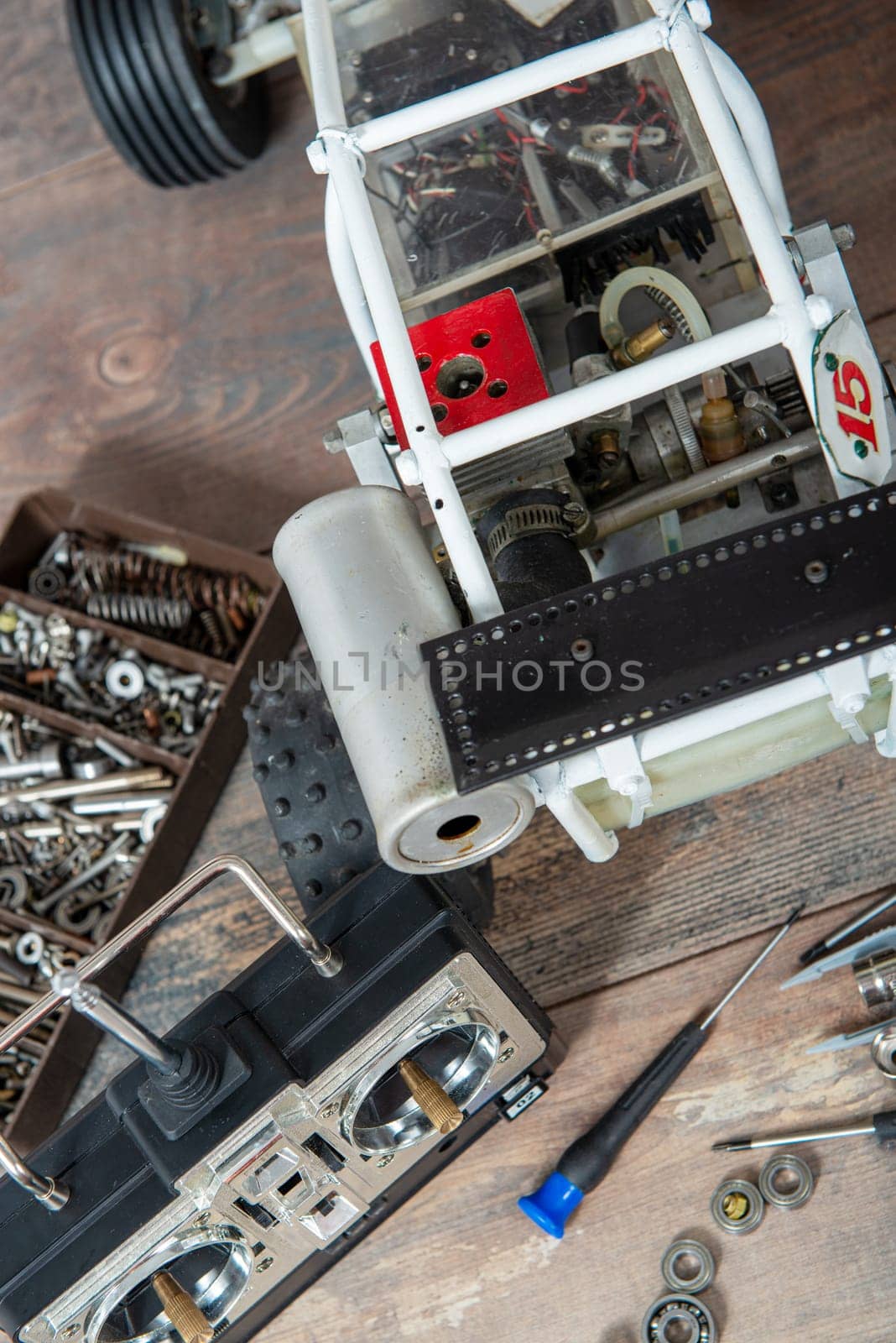 Radio-controlled car model with scattered tools for repairing rc buggy models and a control panel.