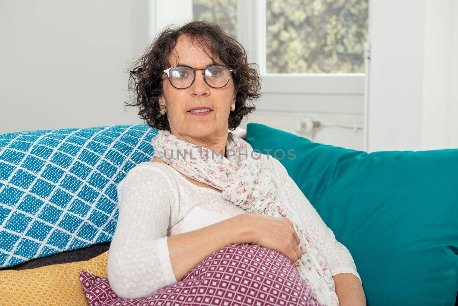 Pretty brunette senior woman relaxing on a couch