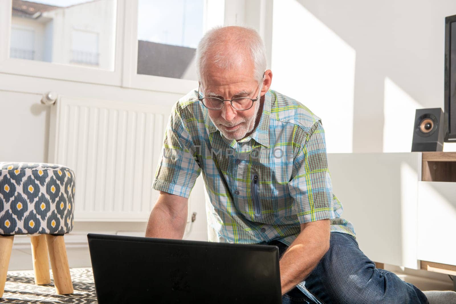 Mature man lying on floor and using a laptop