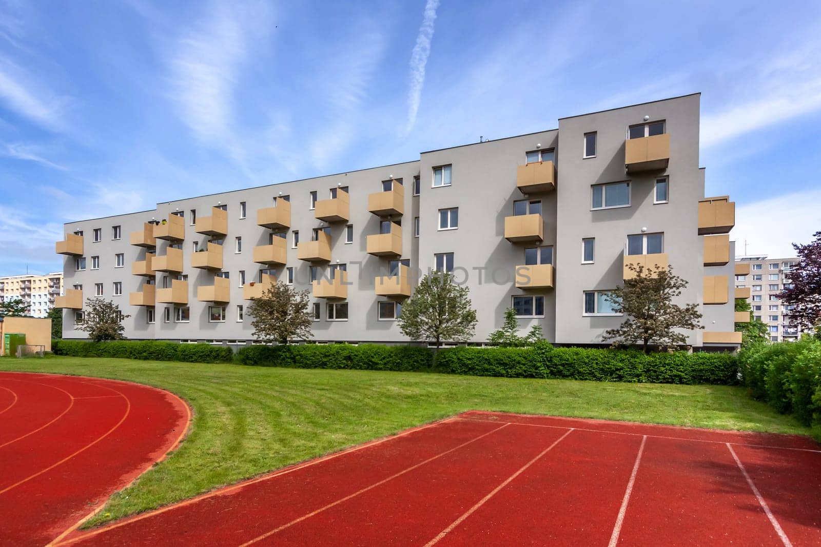 A large brick building with a athletic track. High quality photo
