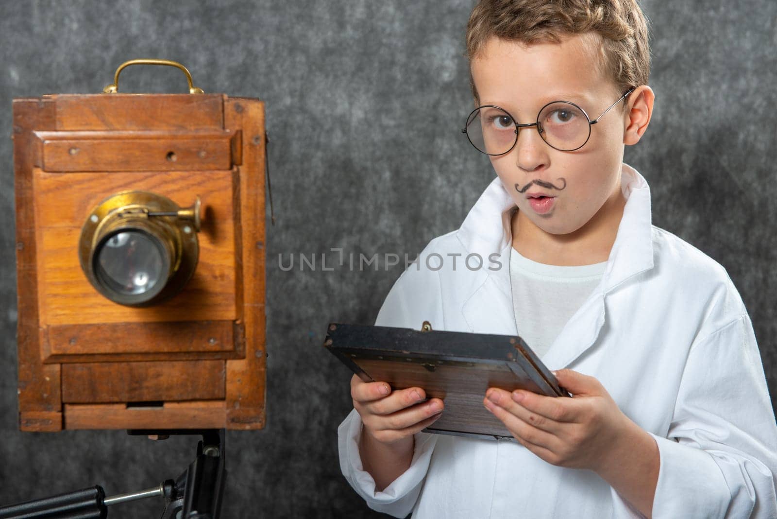 cheerful boy retro photographer with a vintage wooden camera