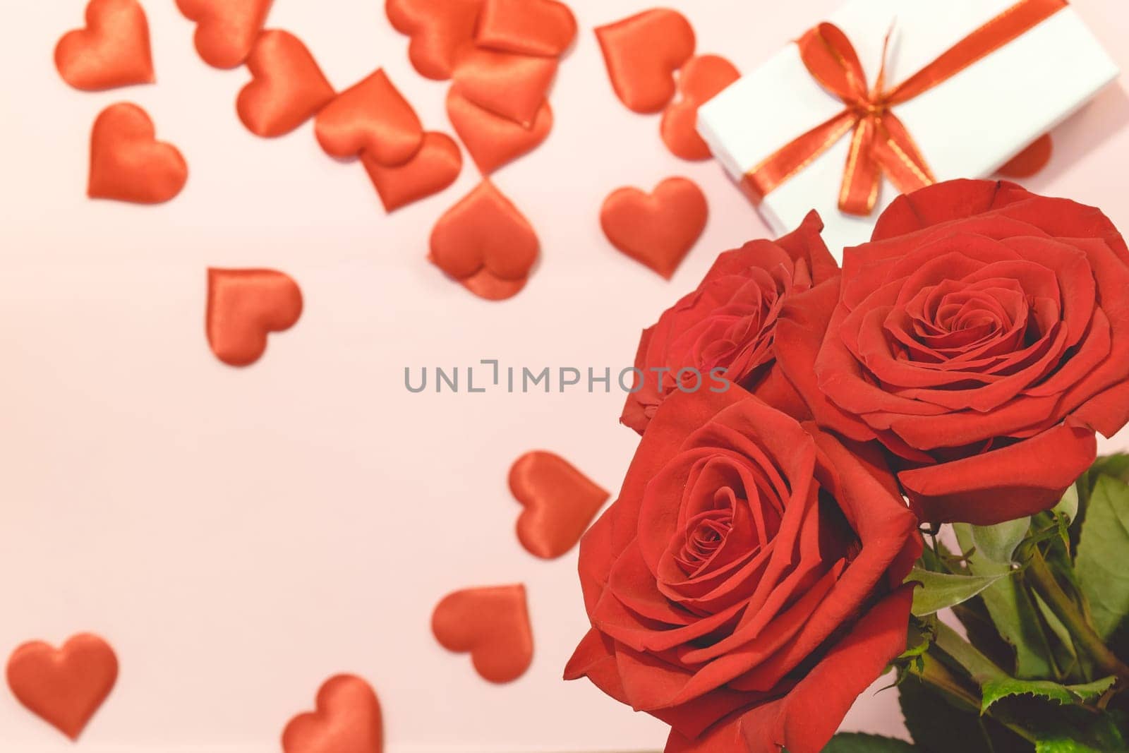 Valentine's day background,Red rose with red hearts and gift box on pink background,For card and wedding background. Copyspace