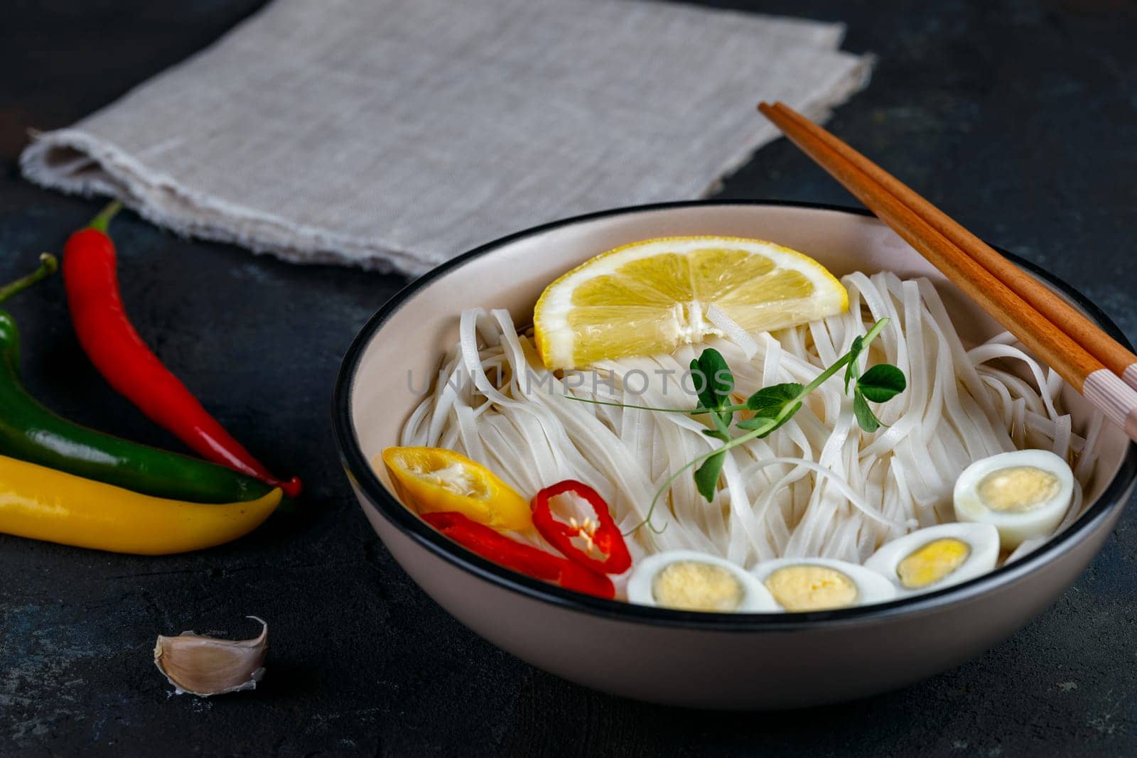 Rice noodles Asian cuisine with quail eggs chili pepper and pea sprout