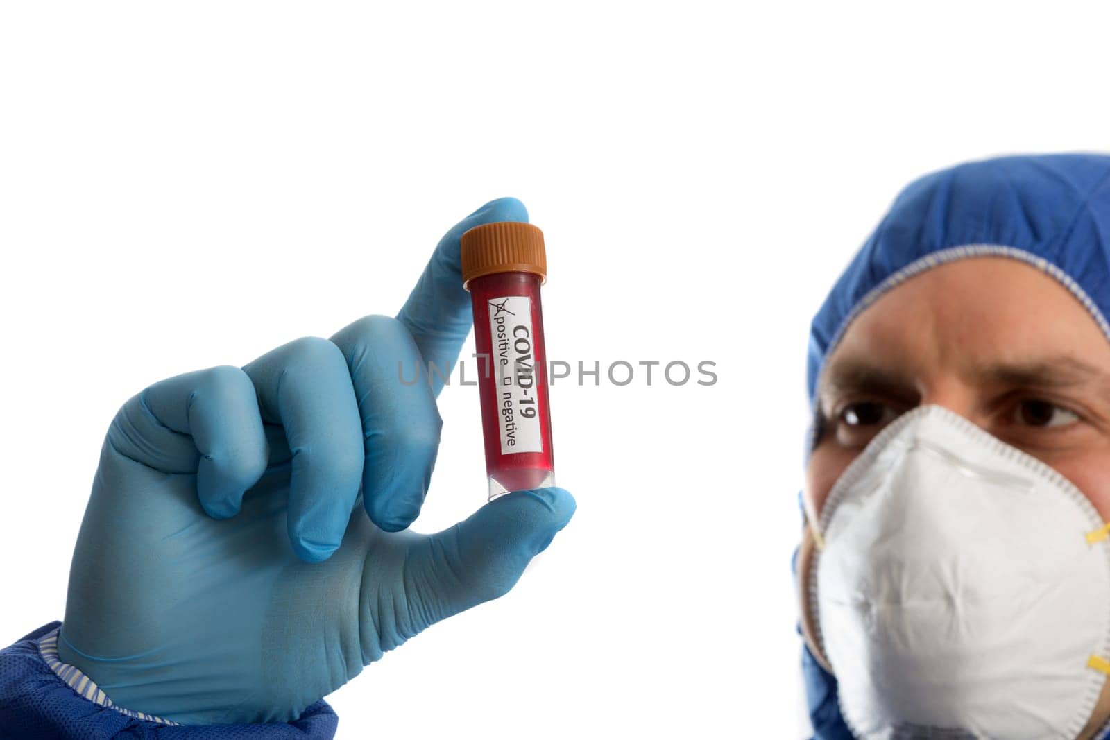 Doctor in protective clothing looking on blood sample with positive marker. COVID -19 virus.