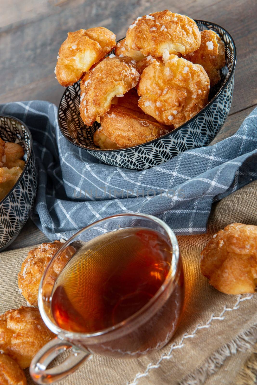 Chouquette, french choux pastry and tea on the wooden table