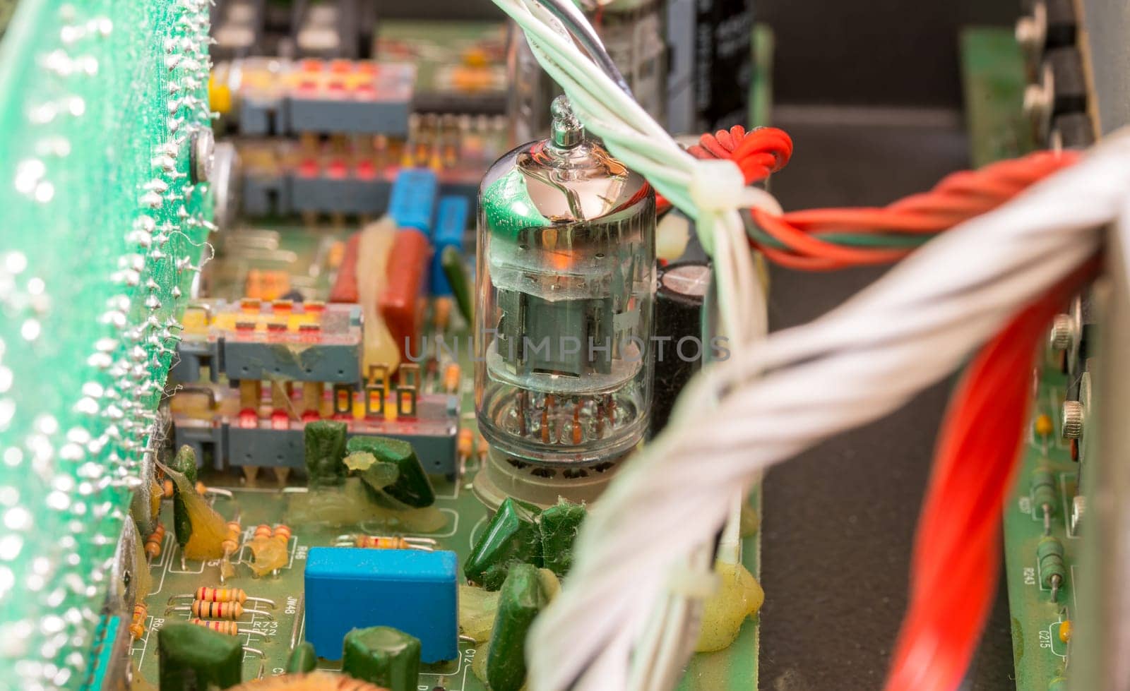 Electrical assembly with glowing tube on a circuit board with electrical components and cables
