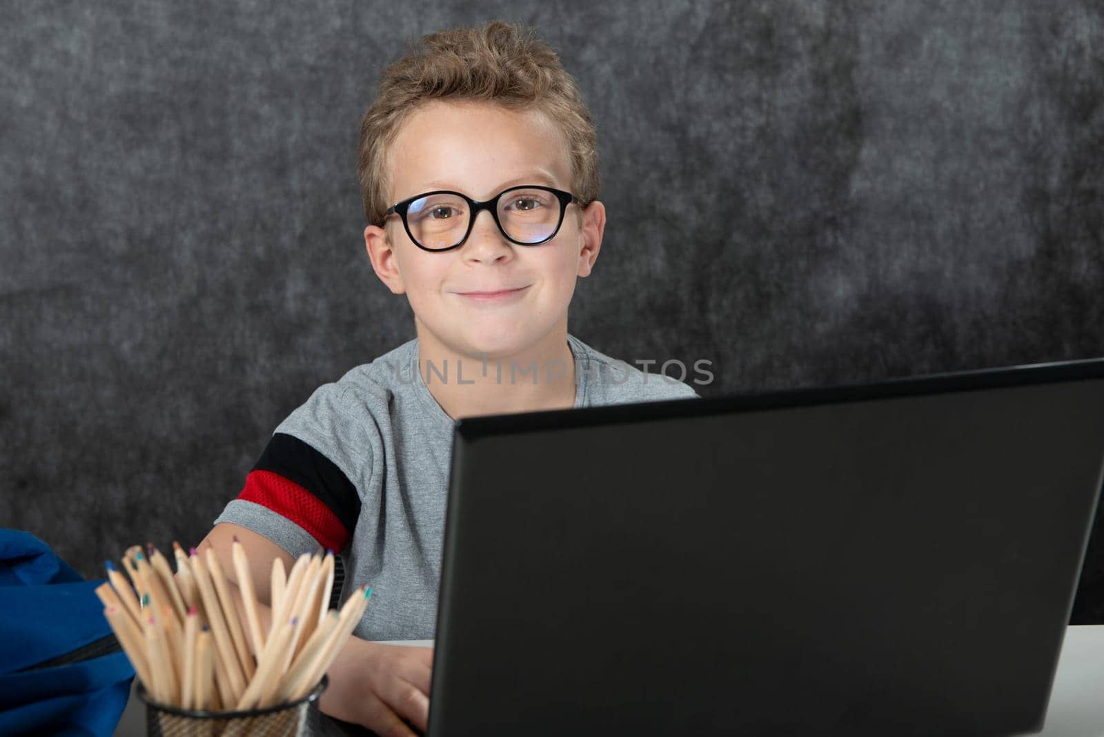 serious boy sitting with a laptop computer