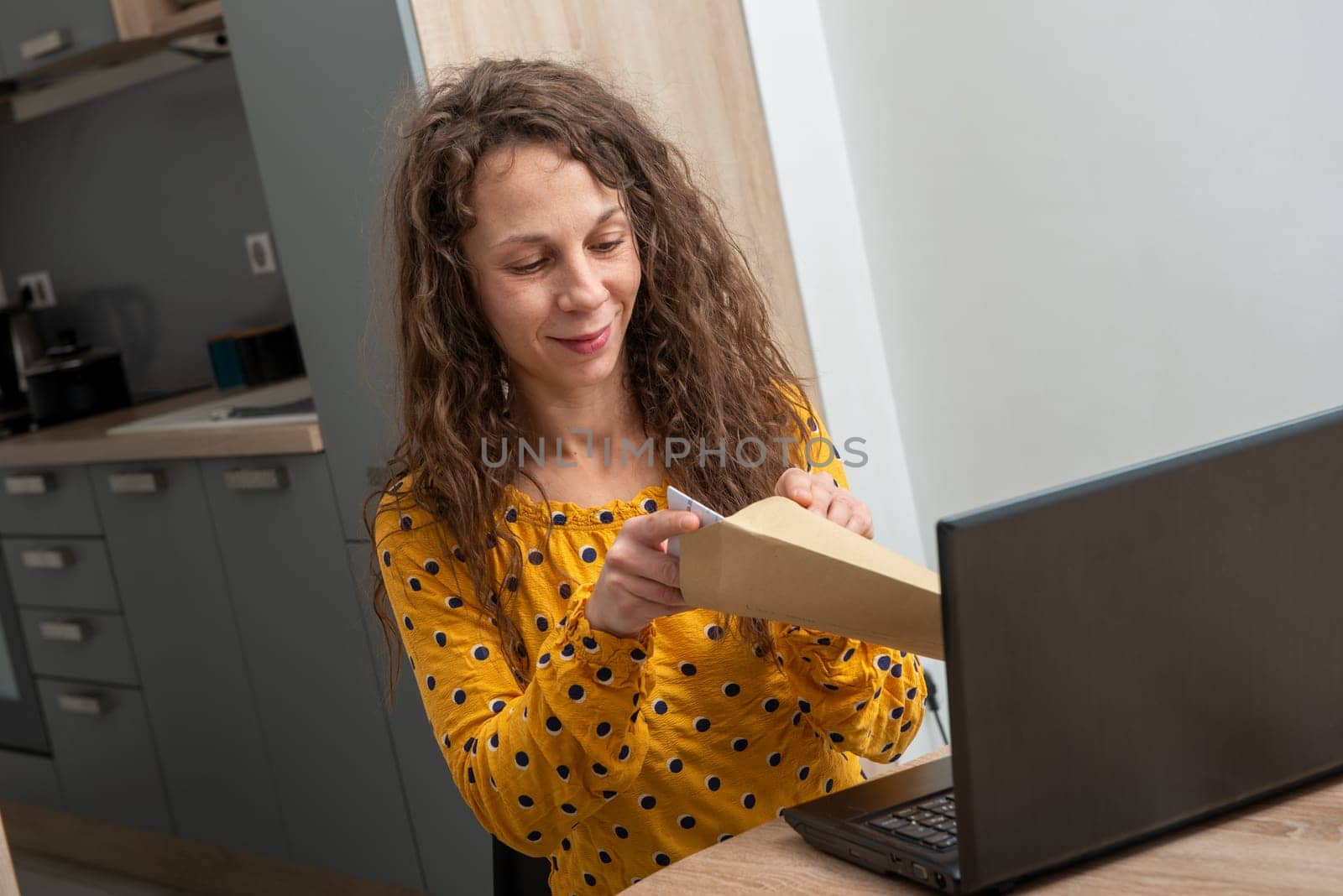 a young woman looking at received mail at home