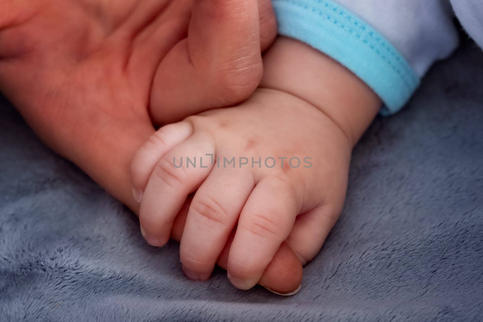 Baby hand holding mother's finger
