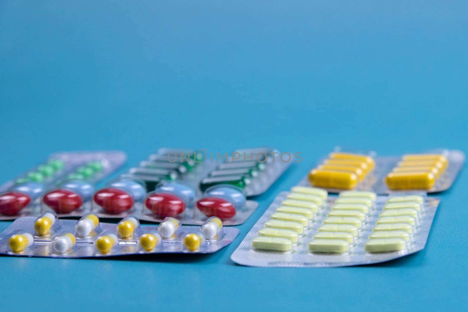 Lemon, ginger, and chapel against multi-colored tablets. The concept of choosing a healthy diet versus taking medication. Top views with clear space