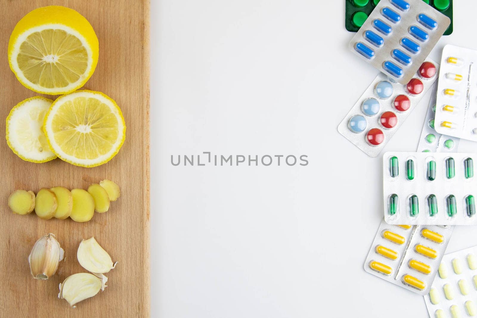 Lemon, ginger, and chapel against multi-colored tablets. The concept of choosing a healthy diet versus taking medication. Top views with clear space