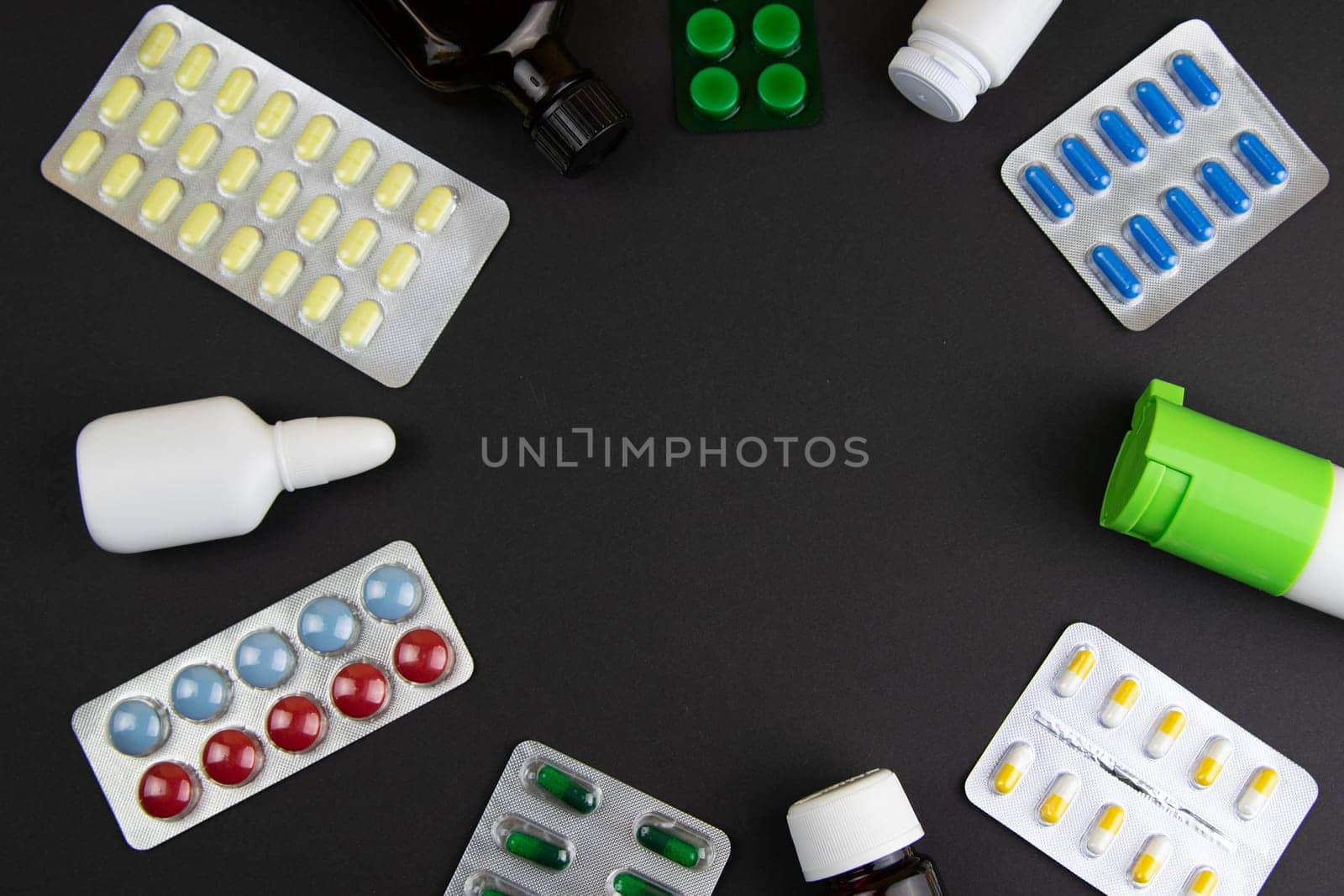 Pills of different colours lay on blue background. Colorful antibacterials pills, capsules of medicine.