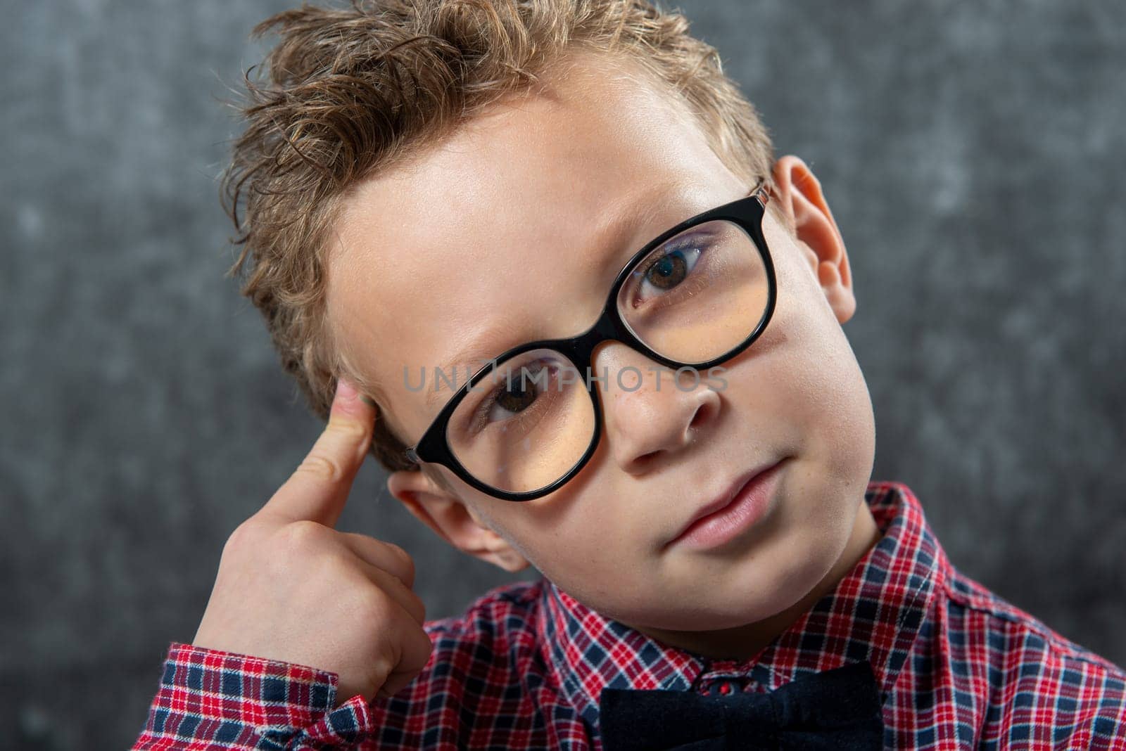 a portrait of pensive cute child with checkered shirt