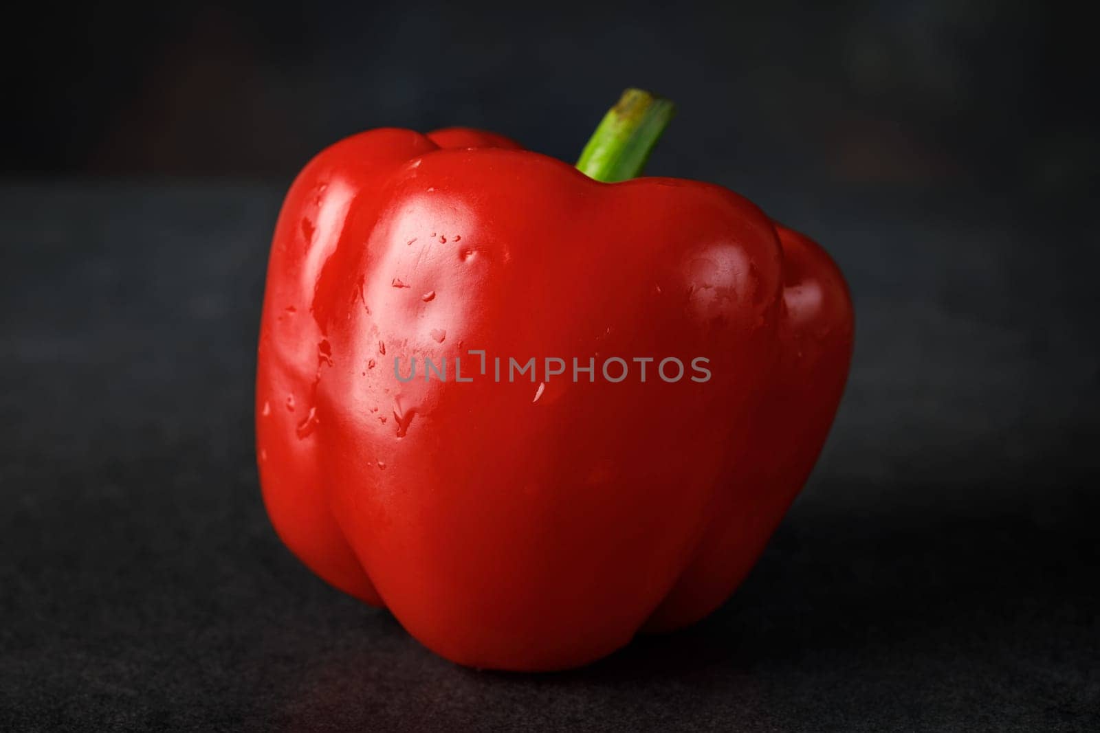 Red sweet pepper close-up against a dark background