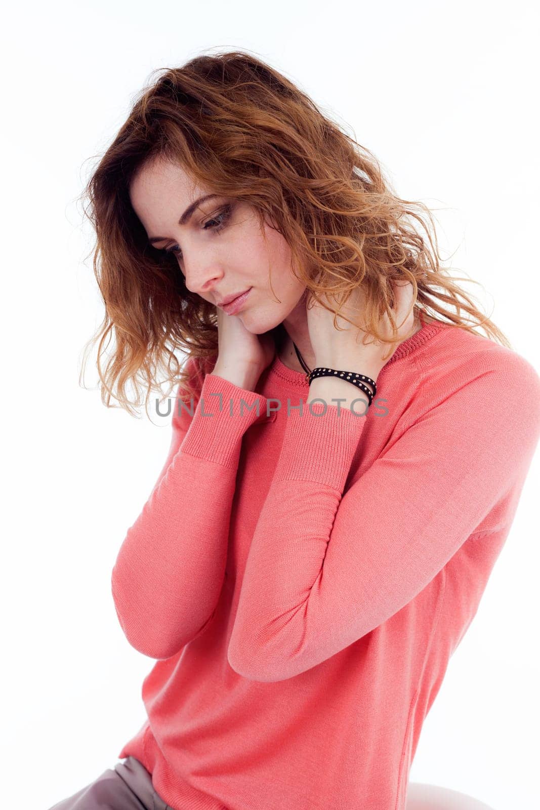Portrait of cute joyful woman with trendy hairstyle wearing basic t-shirt talking on mobile phone isolated over white background.