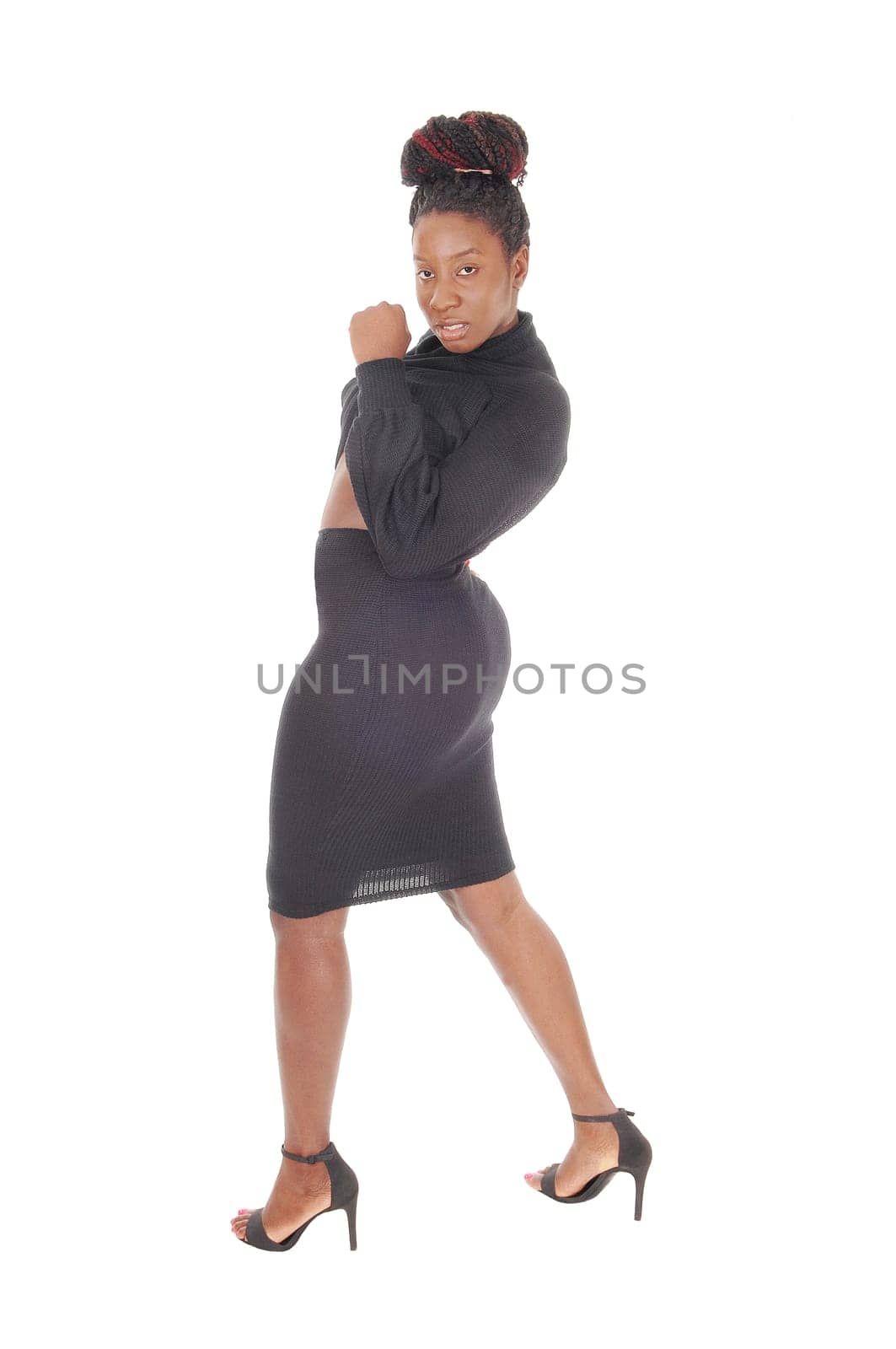 A beautiful young tall African American female standing in a tight.gray dress, showing her figure, isolated for white background.