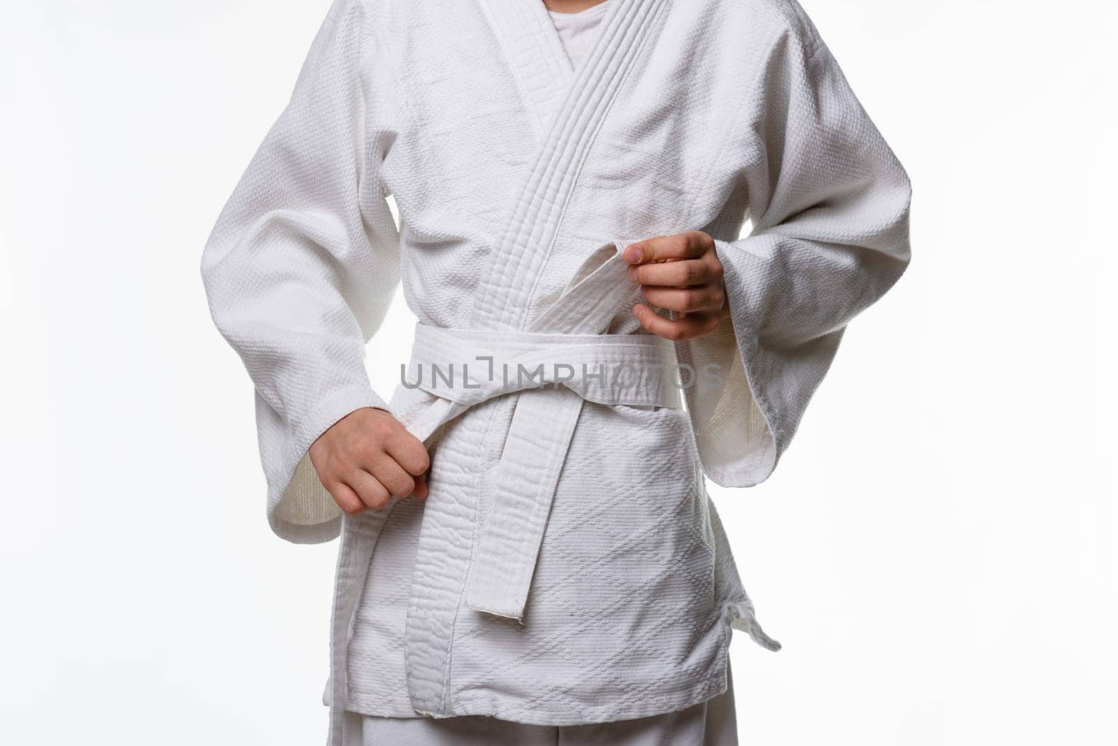 Stages of correct tying of the belt by a teenager on a sports kimono, step six