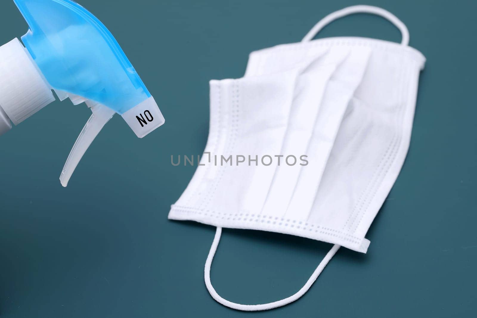 Disinfection spray with protection face mask on the color background