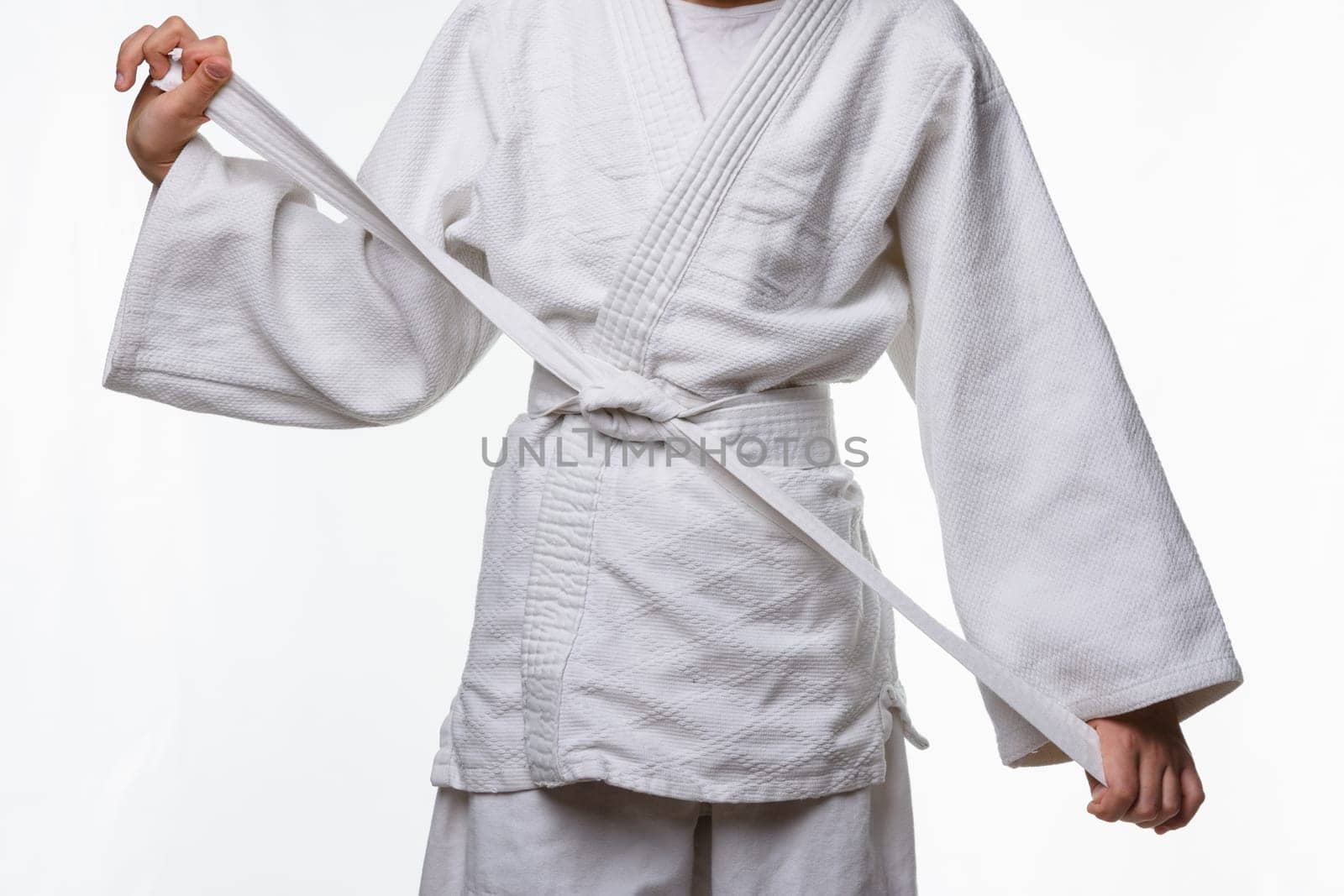 Stages of correct tying of the belt by a teenager on a sports kimono, step nine