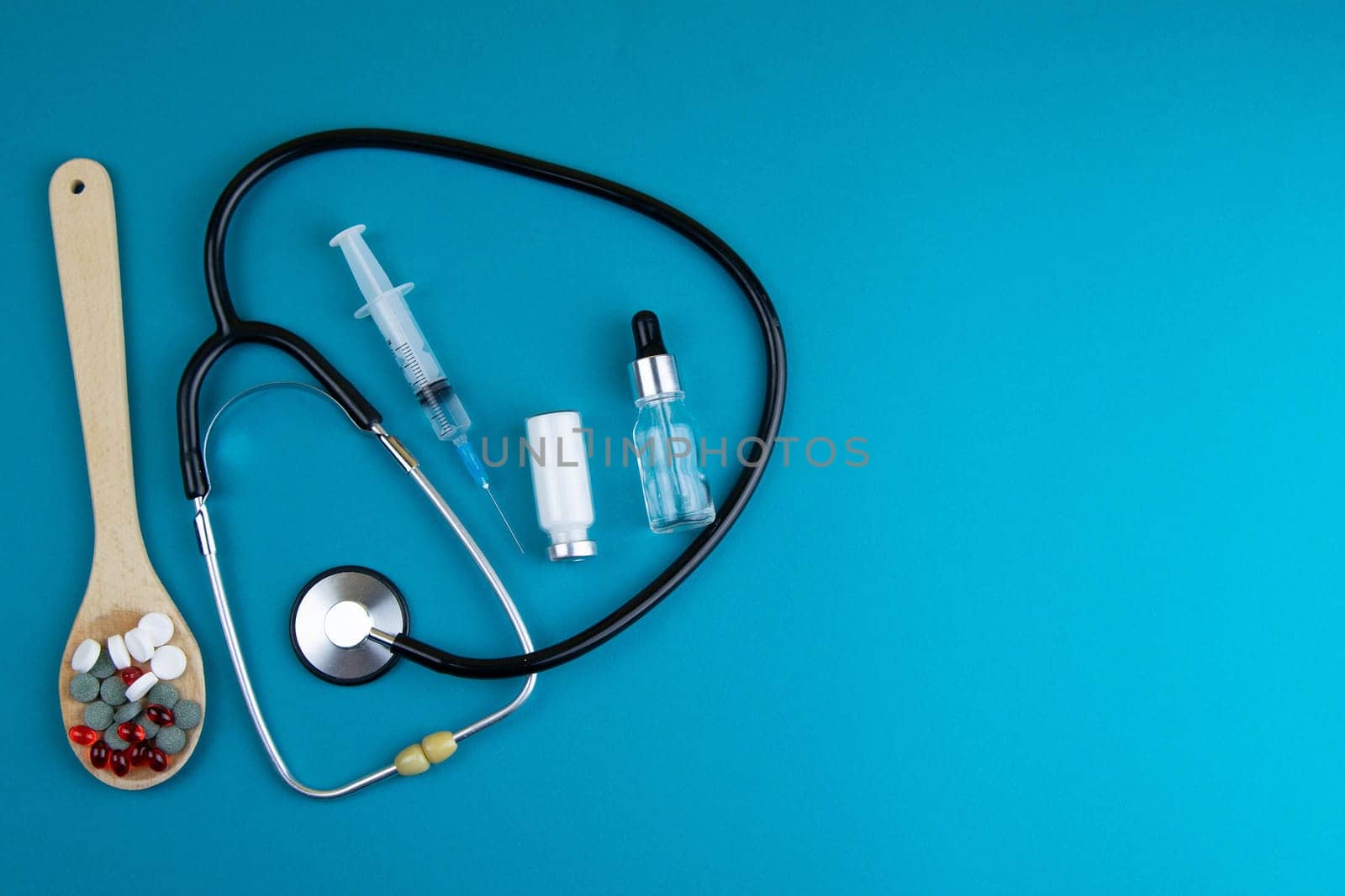 Pills of different colours lay on blue background. Colorful antibacterials pills, capsules of medicine.