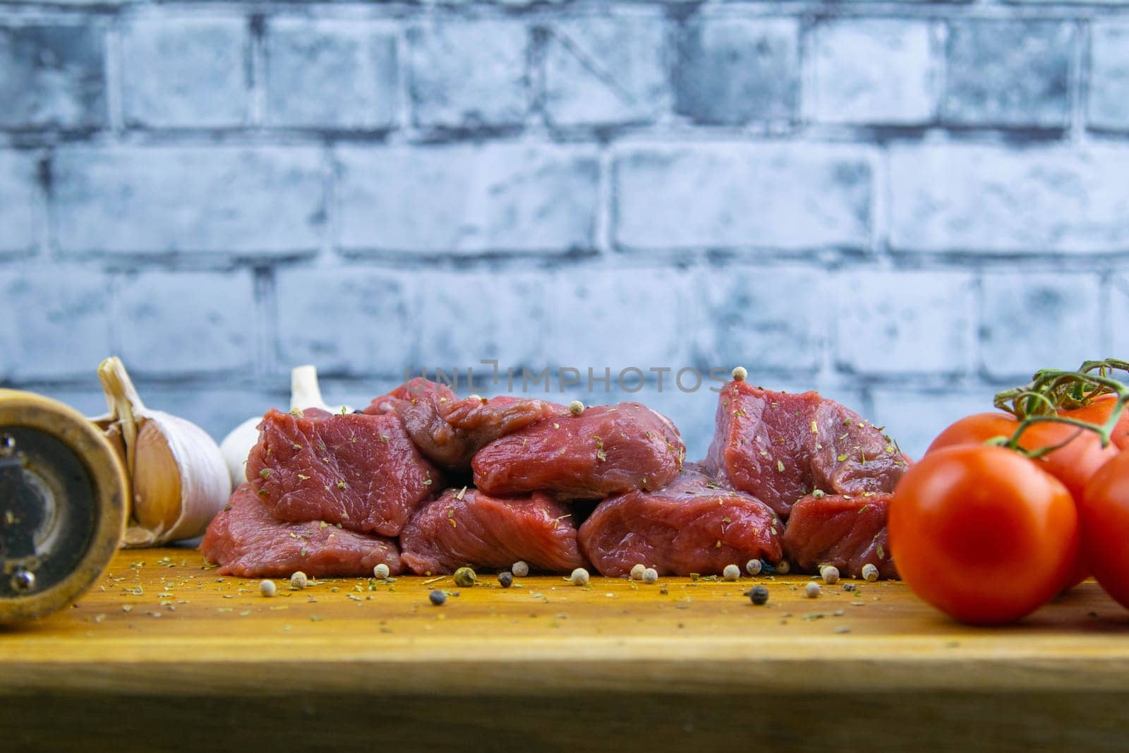 Preparing for the preparation of hamburgers. On a wooden board are lettuce leaves, chopped: tomatoes, cucumbers, onions, cutlets and sauces.