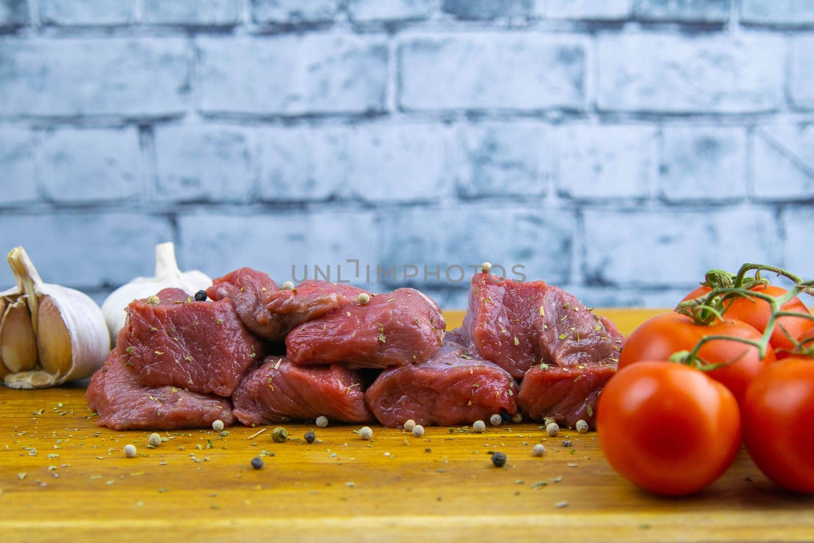Preparing for the preparation of hamburgers. On a wooden board are lettuce leaves, chopped: tomatoes, cucumbers, onions, cutlets and sauces.