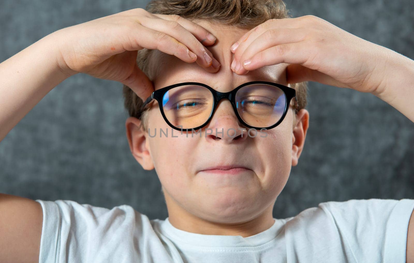 a boy with glasses has a headache