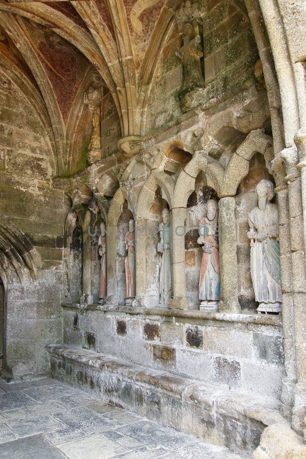 Plouha, France, August 15, 2019: Chapel of Kermaria an Iskuit - medieval wooden statues of saints - apostles - at the entrance to the chapel of Kermaria an Iskuit from 13th century